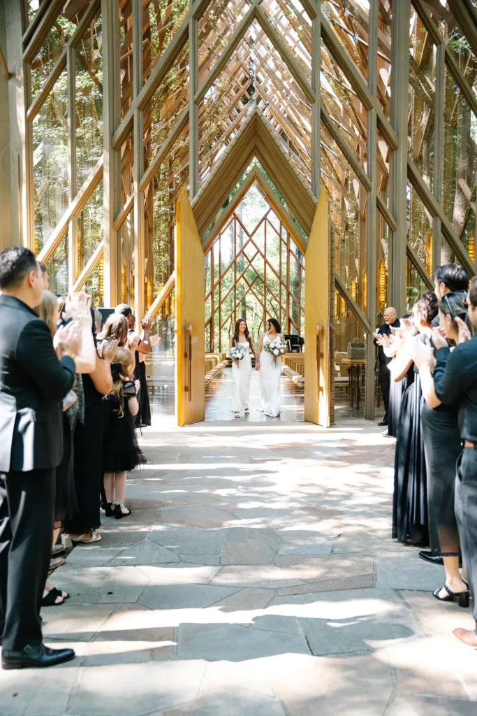 LGBTQ couple walking down the aisle during their wedding ceremony at Anthony Chapel in Hot Springs, Arkansas.
