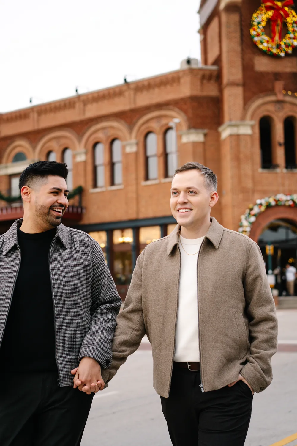 Gay couple holding hands while walking together during an engagement session in Grapevine, Texas.