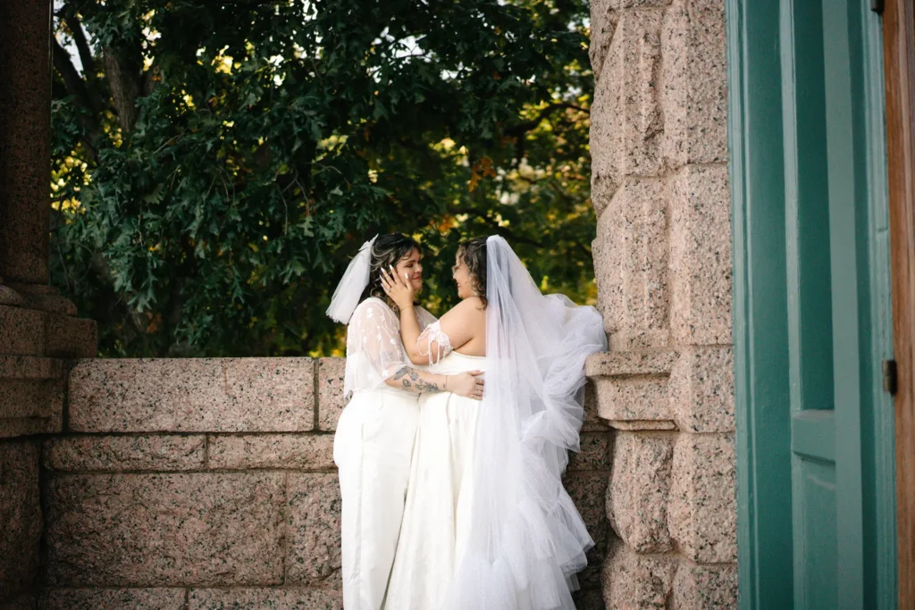 Two brides embrace outside the Fort Worth courthouse after their queer LGBTQ elopement ceremony.